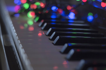 Christmas garland with lights on an electronic piano - decoration for the celebration of Christmas...