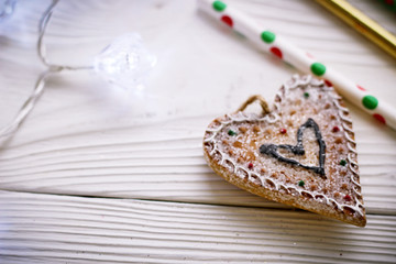 holiday straws for drinking and gingerbread heart cookies on wooden table