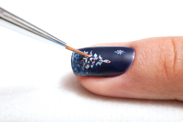Manicure in beauty salon.Finger closeup on a white background. Christmas nail design.
