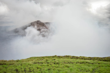 Fototapeta na wymiar Very active heavily fuming crater of the Masaya Nindiri volcanic duo in Nicaragua. Dramatic sky. Central America