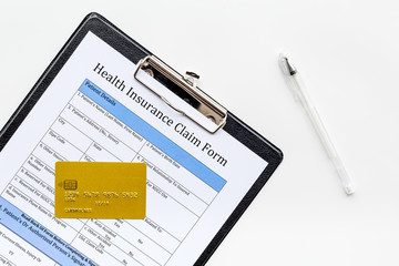 Buy health insurance. Document, pad, pen and bank card on white background top view