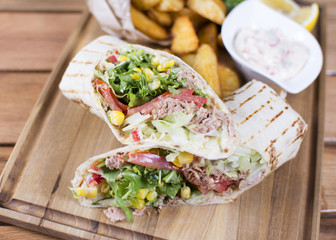 Burrito with grilled chicken and vegetables. Shawarma from juicy beef, lettuce, tomatoes, cucumbers, paprika and onion in pita bread.