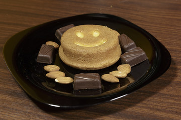 Obraz na płótnie Canvas Cookies, Chocolate and Almonds on a Black dish. Top view. Dark Background