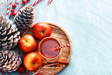 Saison- und Feiertagskonzept. Heißer Wintertee in einem Glas mit Äpfeln und Gewürzen auf einem hölzernen Hintergrund. Selektiver Fokus, Ansicht von oben