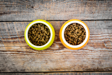 Pet food in bowl on wooden background top view copyspace