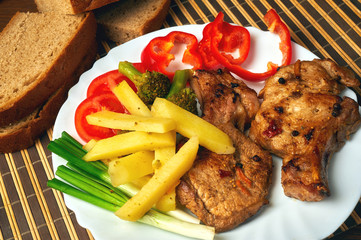 Grilled juicy steak on the bone with vegetables on a dark wooden background.