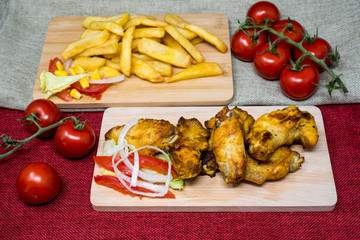 Chicken wings with sauce and golden French fries potatoes