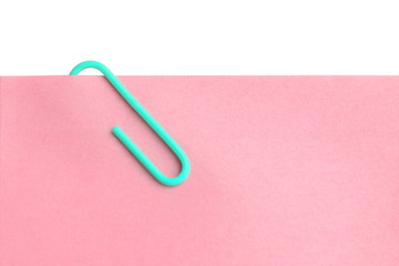 close up pink post it with blue paper clip on white background have copy space for put text