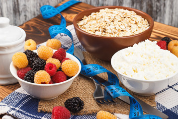 Oatmeal in the bowl with red and yellow raspberries