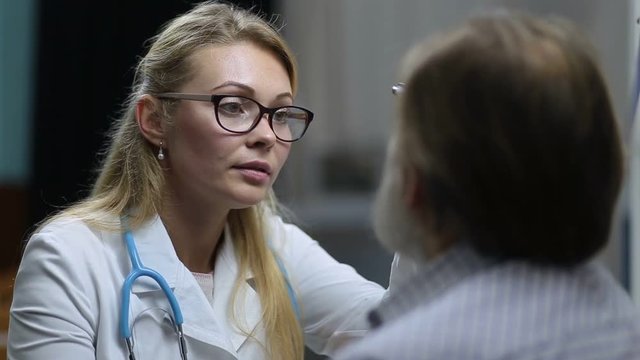 Neurologist checking pupillary reflex with flashlight