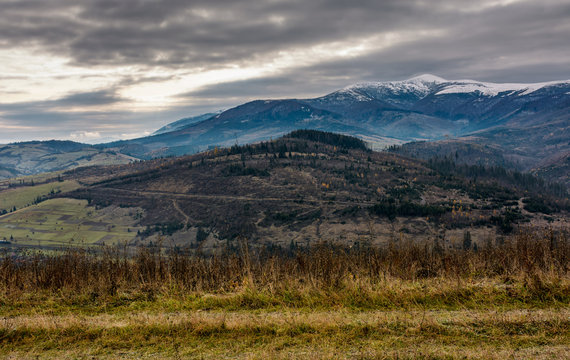 gloomy morning in mountains. autumnal scenery with snowy mountain tops