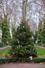 LONDON CITY - DECEMBER 24, 2016: Close up of a Christmas tree decorated with red and silver balls in a little garden