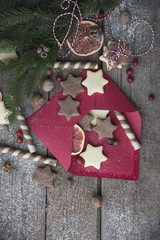 envelope, cookies and christmas decor on a wooden background