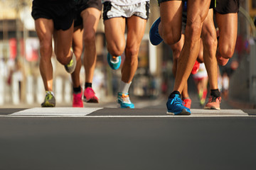 Marathon runners running on city road,detail on legs - obrazy, fototapety, plakaty