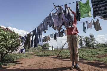 woman hanging washed clothes to dry at garden