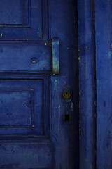 Door handle and lock of blue door on old abandonded house