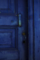Door handle and lock of blue door on old abandonded house