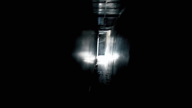 POV trying to escape from a dark room, going towards the light. Horror Halloween scary handheld shot.

