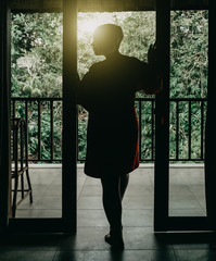 Silhouette of beautiful woman in entrance near tropical forest