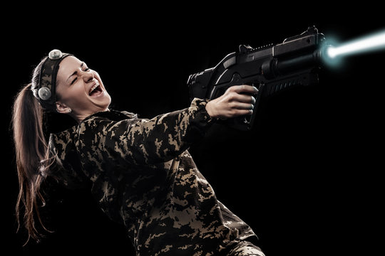 Heavily armed masked soldier isolated on black background. Paint ball and laser tag sport games.