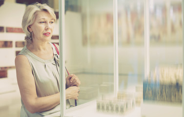 Adult female looking at artwork copper exhibit in the gallery indoors