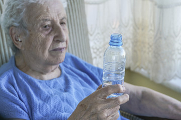 senior woman holding a bottle of drinking water