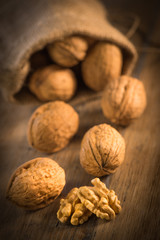Walnut kernels and whole walnuts on rustic old oak table