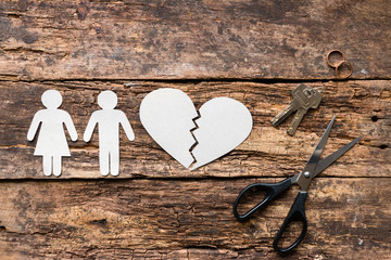 divorced couple near a broken heart on a wooden background