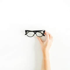 Glasses in woman hand. Minimal flat lay, top view.