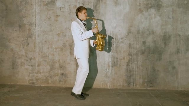 A musician in a white suit plays the saxophone.