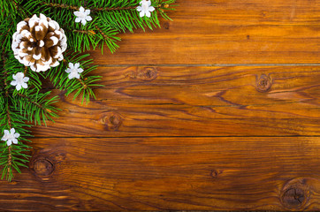 Christmas wooden background with fir-tree and cones top view.