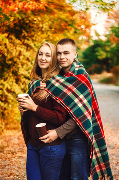 The Relationship Between A Guy And A Girl. A Hot Drink In The Hands. A Blanket Warms Two. Smile On His Face. Sunny Day