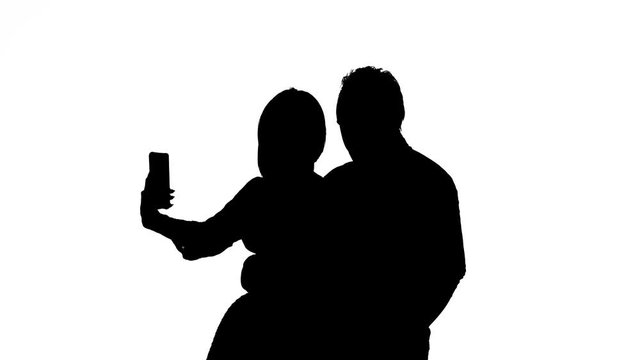 Guy and the girl are making selfies. Silhouette. White background