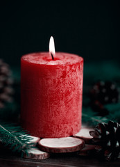 Christmas candle with spruce decoration on dark wooden background. Christmas decoration