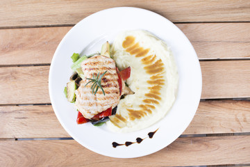Grill chicken breast. Grilled vegetables with chicken breast. Grilled chicken with vegetables on oak table.