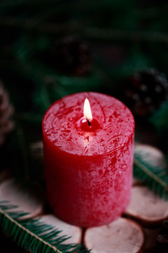 Christmas candle with spruce decoration on dark wooden background. Christmas decoration