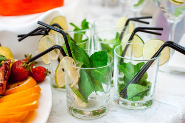 mohito and fresh fruits and berries of bright colors cut in small pieces served in restourant