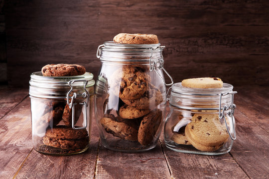 Chocolate cookies in a glass jar on white background.