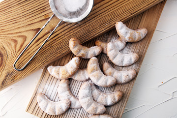 Vanille Kipferl cookies for christmas on brown wood with sugar.