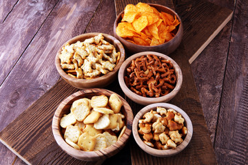 Salty snacks. Pretzels, chips, crackers in wooden bowls.