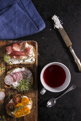 Fresh sandwiches on a wooden cutting board. Healtcare concept on dark background.