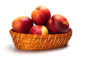 Fototapeta na wymiar Fresh fruit nectarines in the basket, on white background