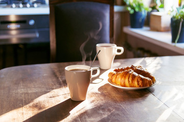 breakfast for two person with cup of hot coffee and fresh croiss
