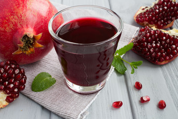 Pomegranate juice in the glass on the grey napkin