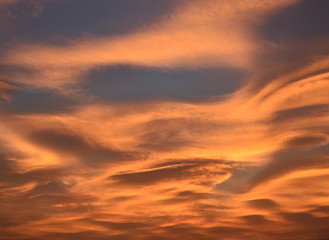 Strange and unusual cloud with spiral pink, orange, golden and blue at sunset in the sky of Turin, Italy.