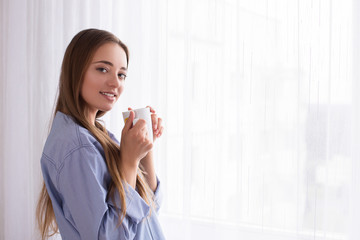 good morning girl lies drinking coffee drink tea at the window