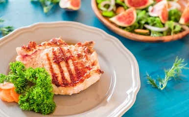 Grilled steaks on a gray plate blue background