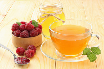 healthy background. raspberry with raspberry jam, honey and tea on light wooden background