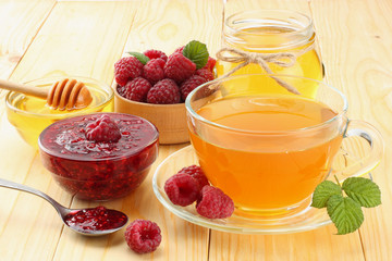 healthy background. raspberry with raspberry jam, honey and tea on light wooden background