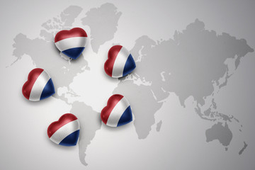 five hearts with national flag of netherlands on a world map background.